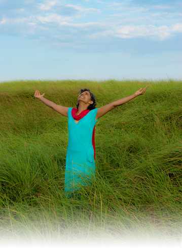 Doctor Priya, standing in a field with her arms flung open - gratitude.