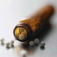 homeopathic tablets spilling from an unmarked brown bottle